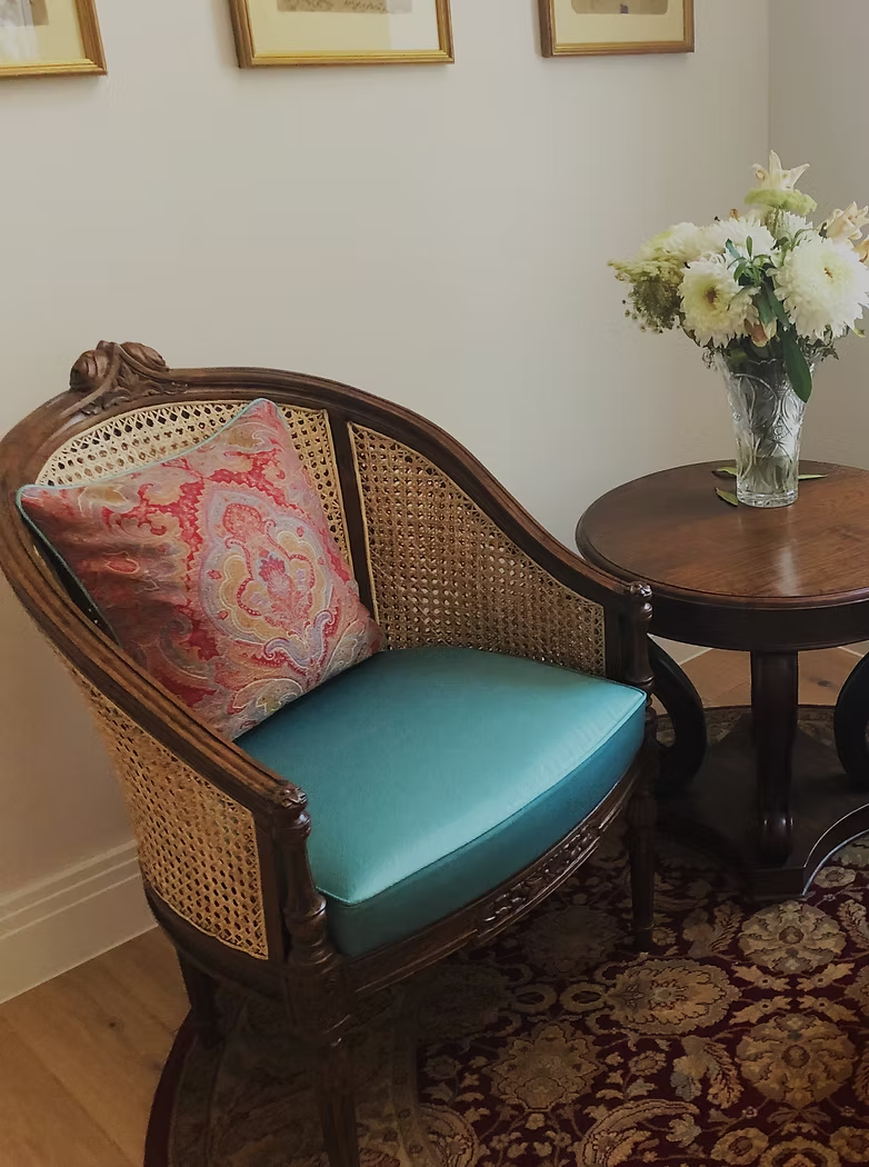 Rattan-backed dining chair with a newly made turquoise seat cushion