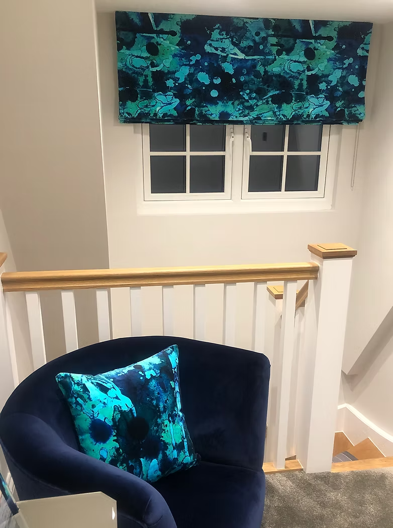 Navy reupholstered chair with a patterned cushion beneath a matching stair landing blind