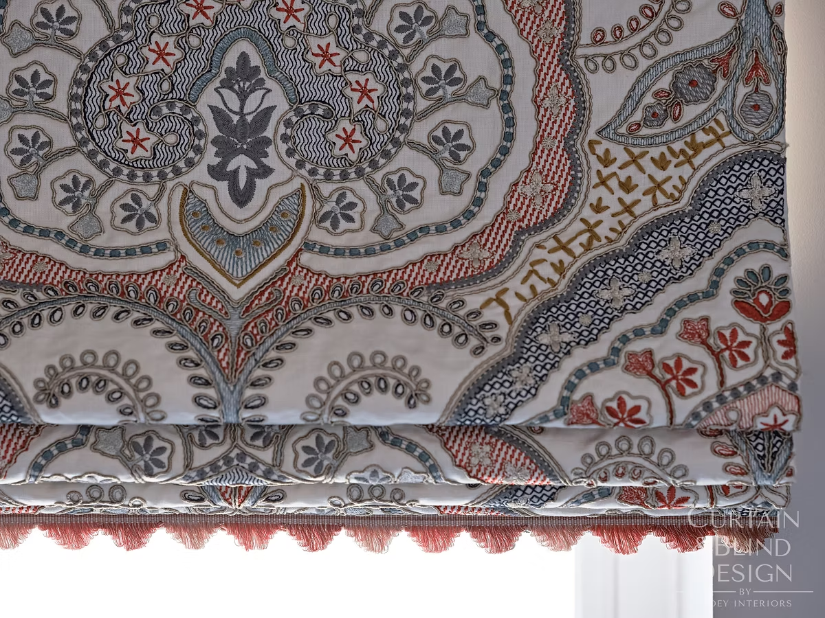 Close detail of a paisley Roman blind finished with tasselled trim