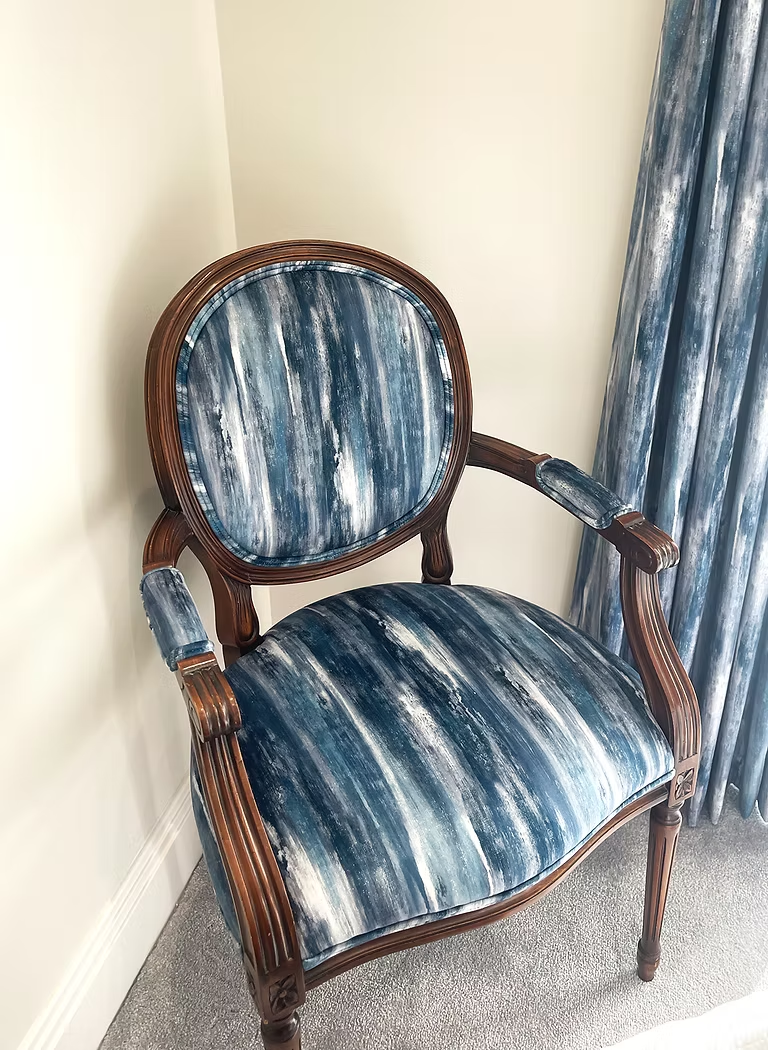 Carved wooden armchair reupholstered in blue and silver textured stripe fabric