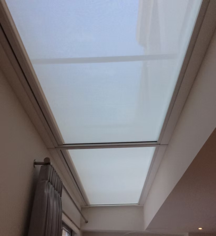 Translucent blinds fitted to roof glazing along a narrow interior corridor