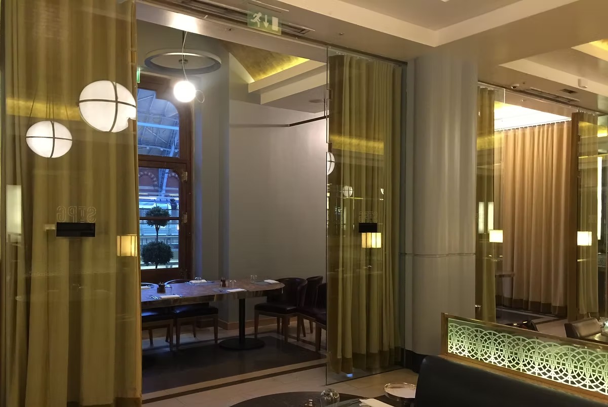 Contract curtains in olive and beige hung floor to ceiling in a restaurant dining room