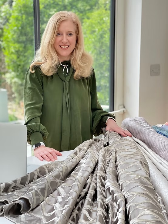 Katherine Adey reviewing a length of interlined curtain fabric in her Pinner studio