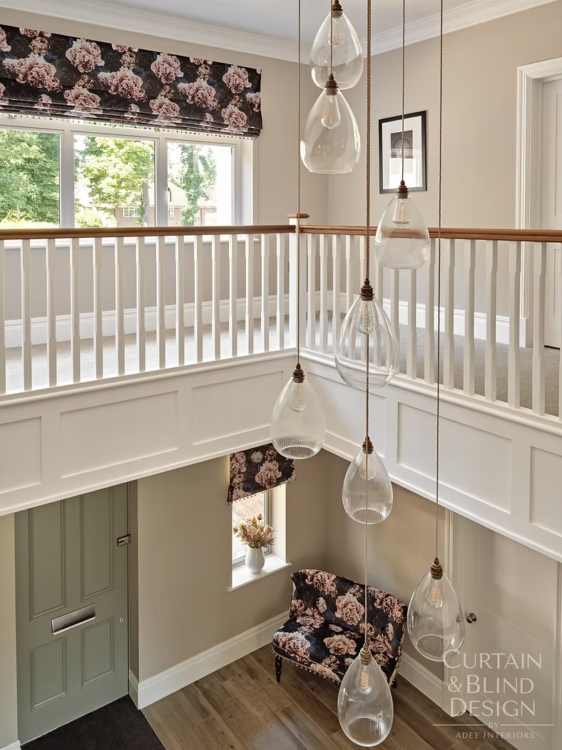 Double-height entrance hall dressed with matching floral Roman blinds